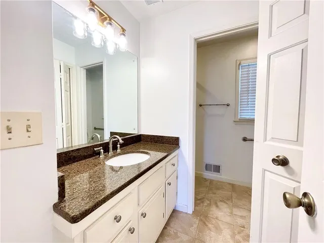 a bathroom with a granite countertop sink and a mirror