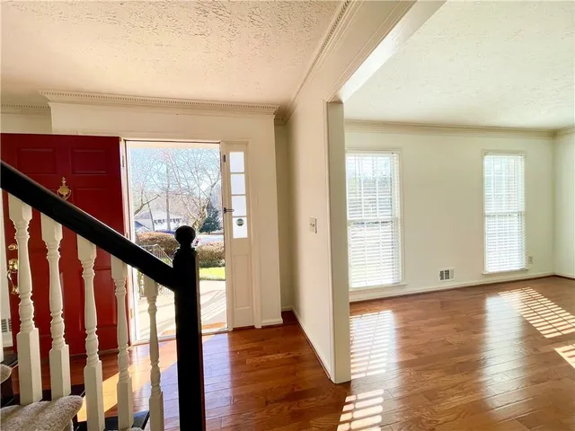 a view of an entryway with wooden floor and stairs