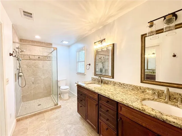 a bathroom with a granite countertop sink mirror shower and