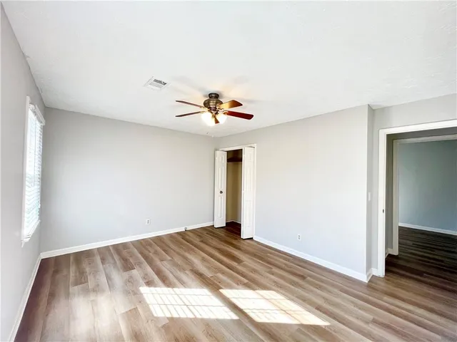 a view of a livingroom with wooden floor and a ceiling fan