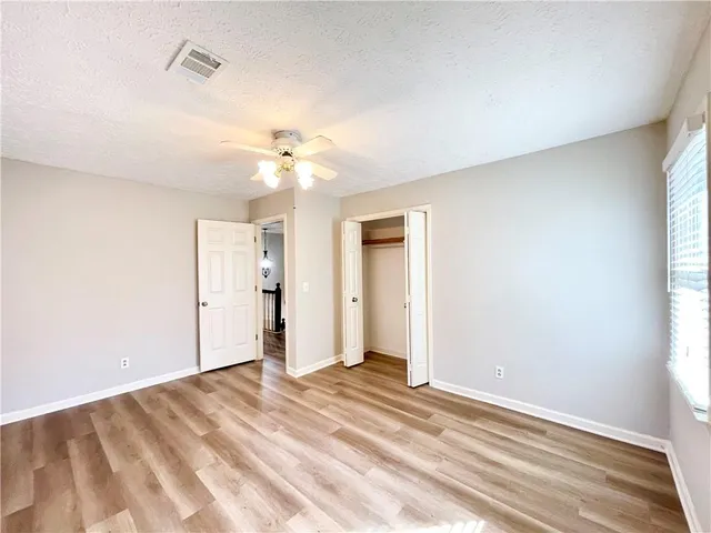 a view of a room with a ceiling fan and window