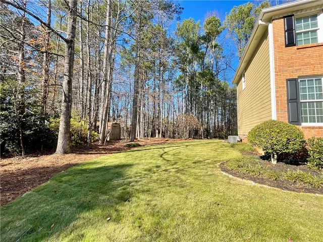 a view of a house with backyard and tree