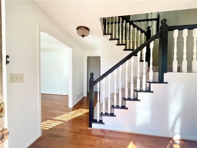 a view of entryway and hall with wooden floor