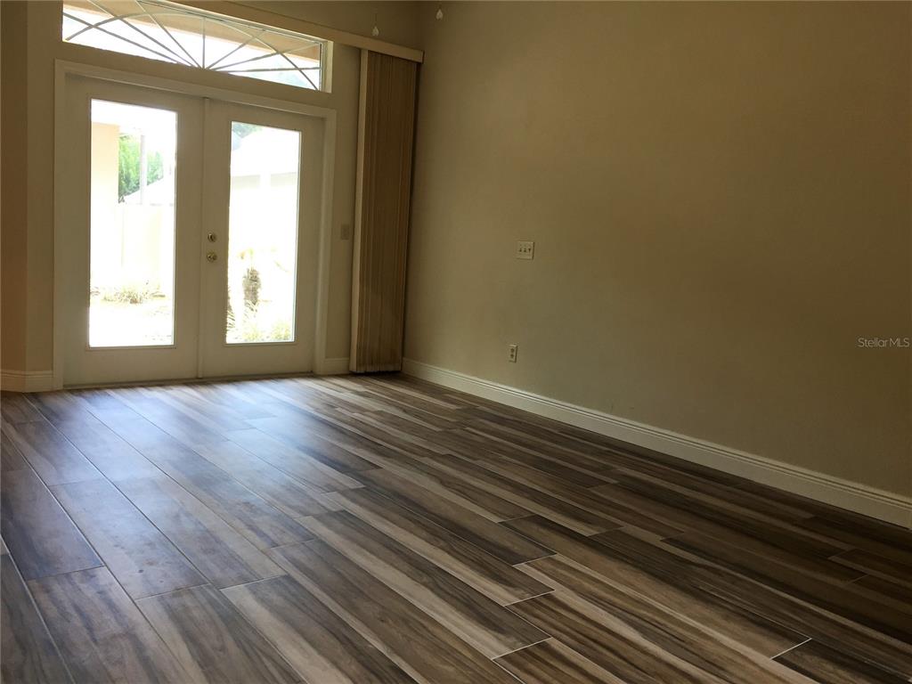 4414 Southwest 91st Drive Gainesville, FL 32608 - Photo 12 of 19 a view of an empty room with wooden floor and a window