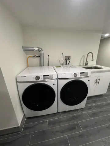 a utility room with sink dryer and washer