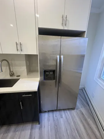 a kitchen with a sink a refrigerator freezer a stove and a wooden floors