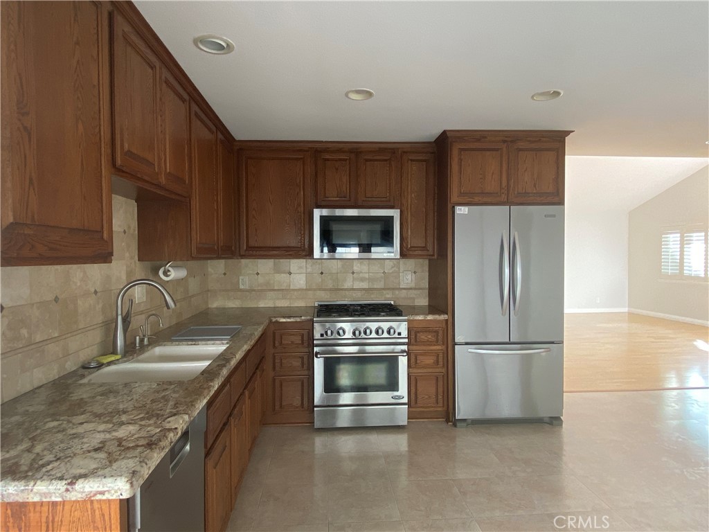 11598 Wake Circle Cypress, CA 90630 - Photo 8 of 20 a kitchen with stainless steel appliances granite countertop a refrigerator stove and sink