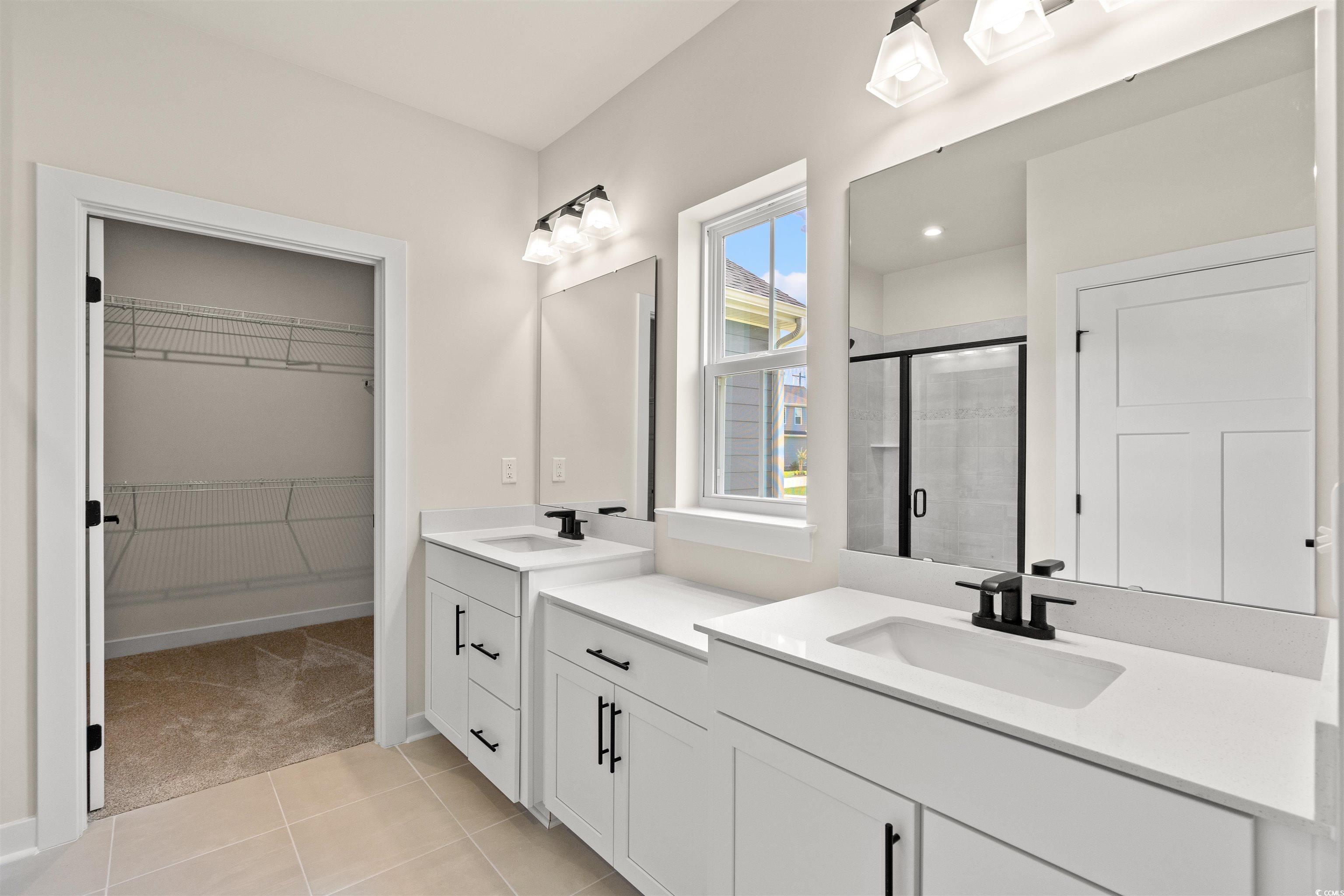 7076 Denim Loop Myrtle Beach, SC 29579 - Photo 15 of 27 Full bathroom featuring a stall shower, two vanities, a spacious closet, and tile patterned flooring