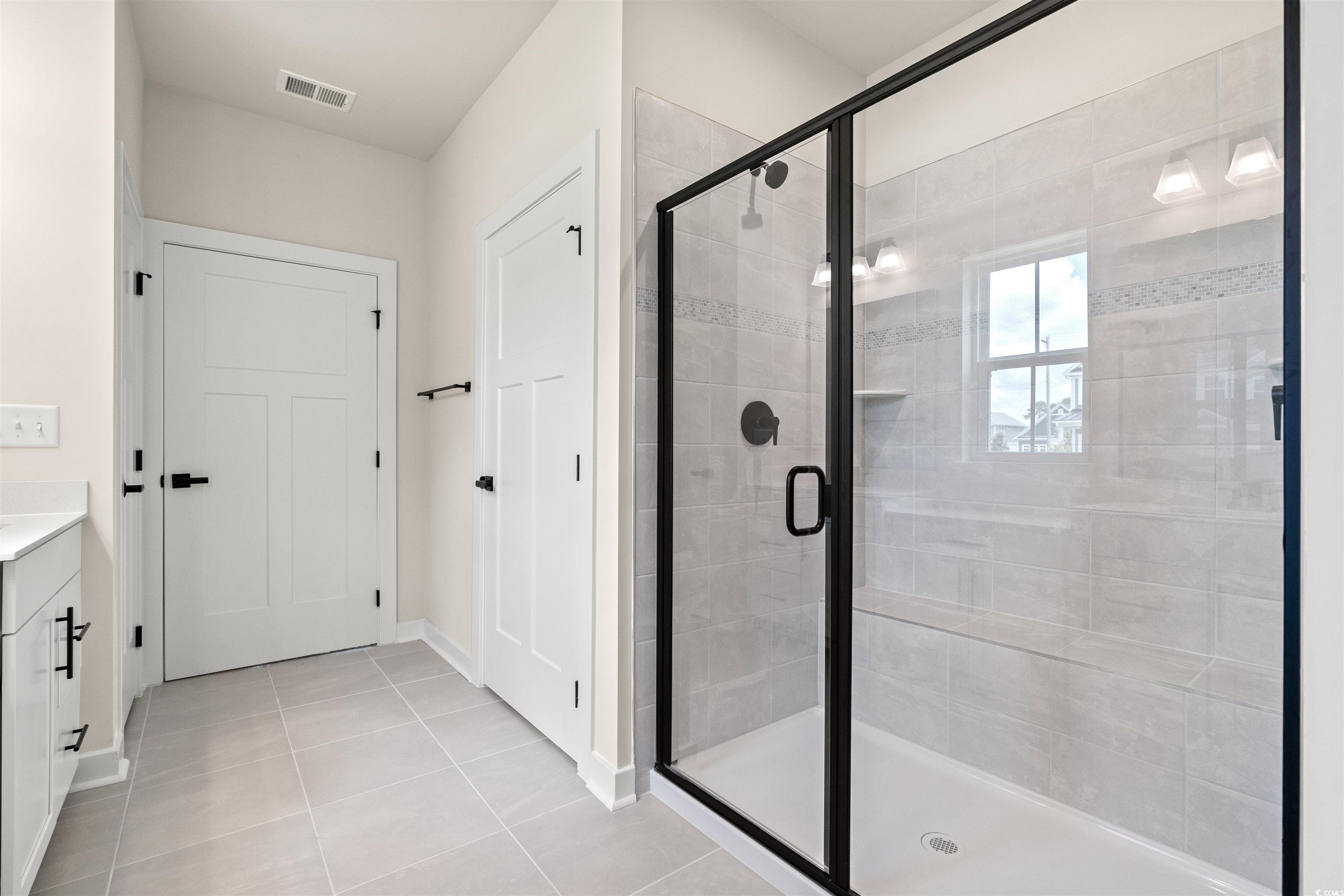 7076 Denim Loop Myrtle Beach, SC 29579 - Photo 16 of 27 Bathroom with a stall shower, vanity, and tile patterned floors