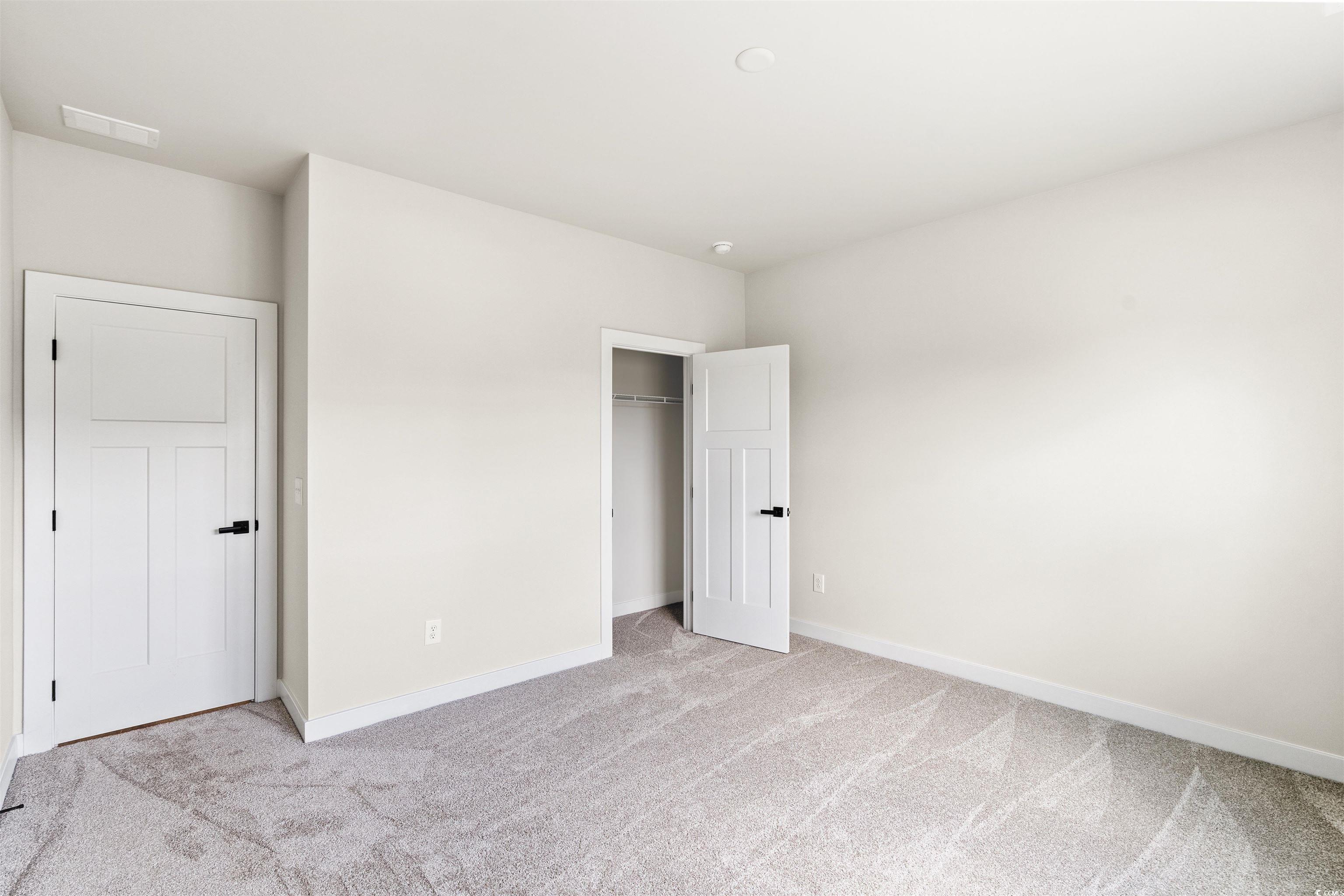 7076 Denim Loop Myrtle Beach, SC 29579 - Photo 19 of 27 Unfurnished bedroom with light colored carpet and a closet