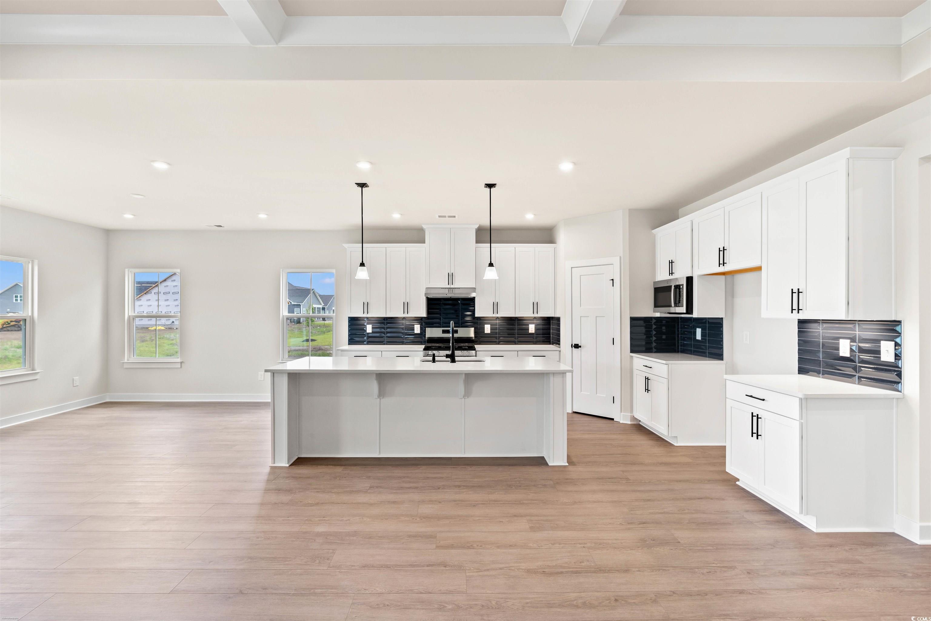 7076 Denim Loop Myrtle Beach, SC 29579 - Photo 9 of 27 Kitchen with stainless steel microwave, backsplash, light wood-style flooring, recessed lighting, and white cabinets