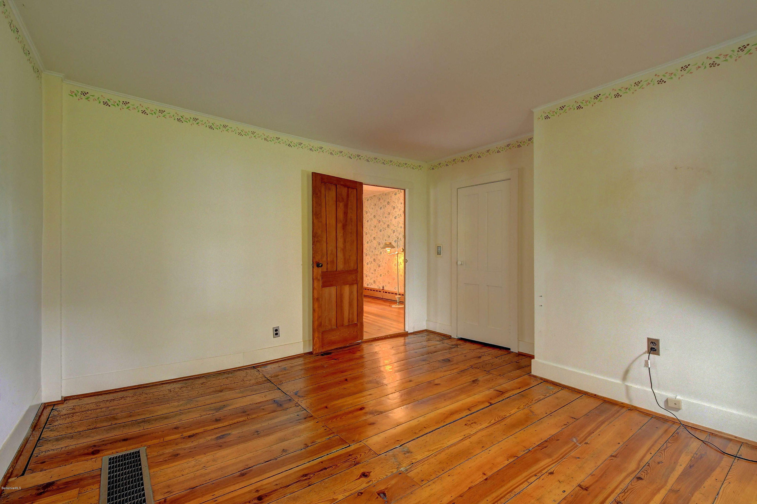 1114 Ashley Falls Road Sheffield, MA 01222 - Photo 21 of 53 a view of an empty room with wooden floor and a window