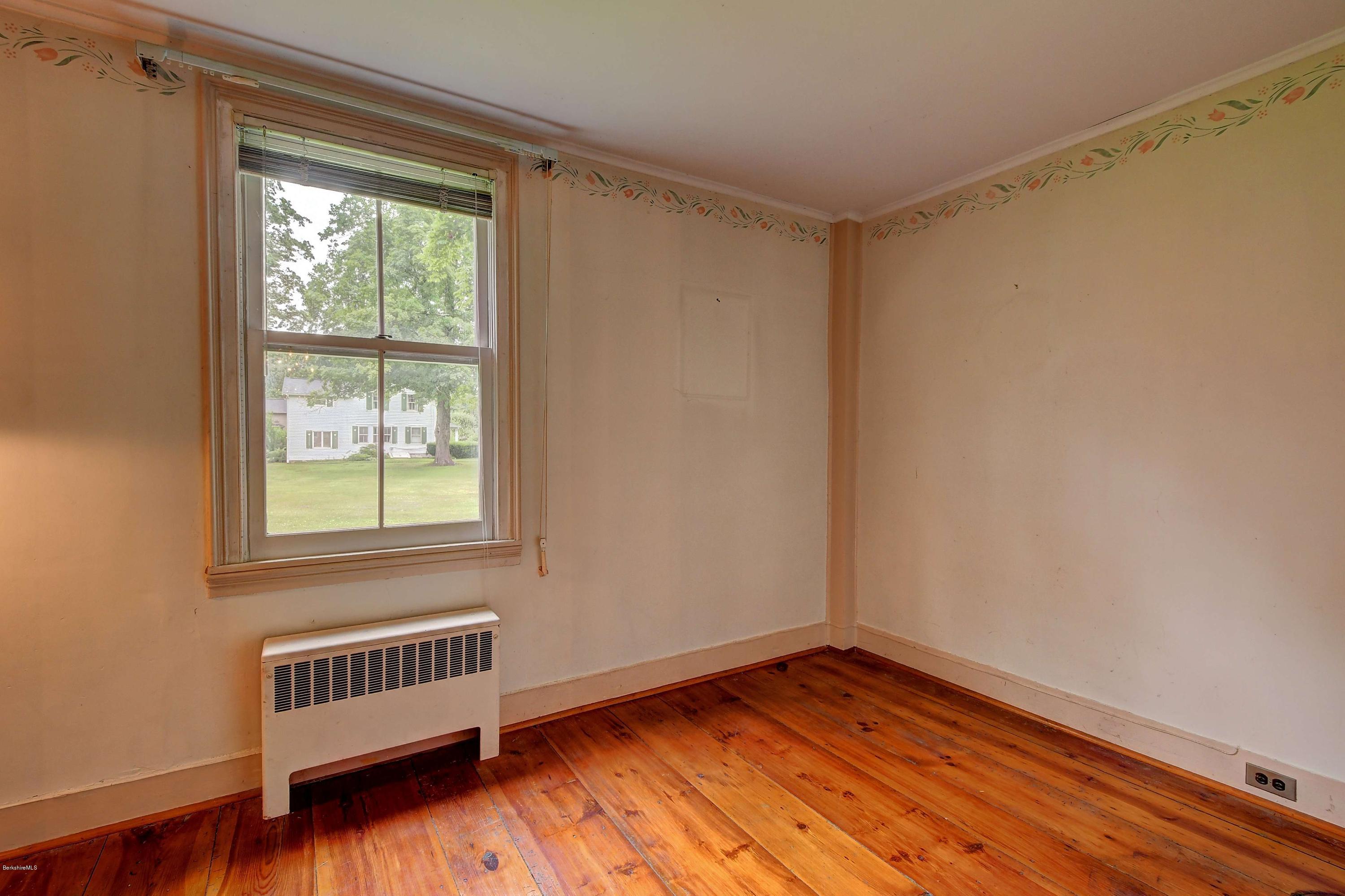 1114 Ashley Falls Road Sheffield, MA 01222 - Photo 22 of 53 a view of an empty room with wooden floor and a window