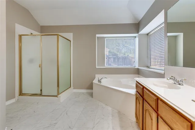 a spacious bathroom with a bathtub sink and mirror