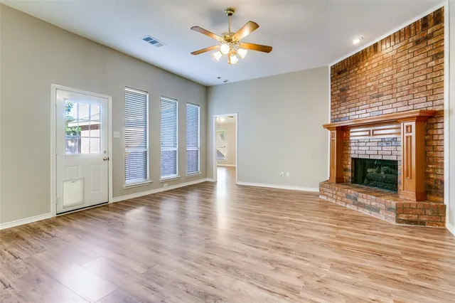 a view of an empty room with window and fireplace