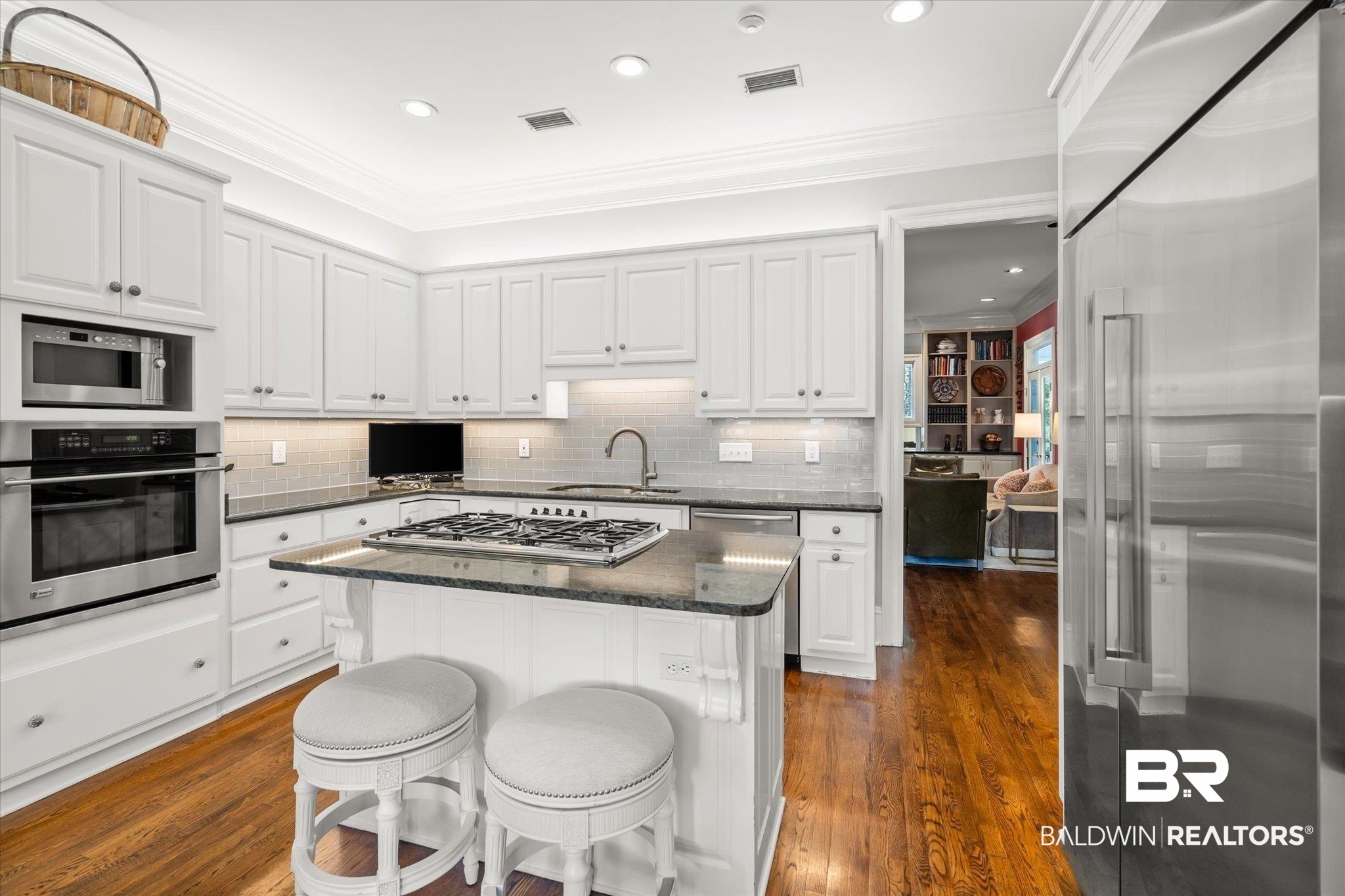 354 Dogwood Lane Mobile, AL 36608 - Photo 13 of 44 Kitchen with dark hardwood / wood-style floors, stainless steel appliances, sink, a center island, and white cabinets
