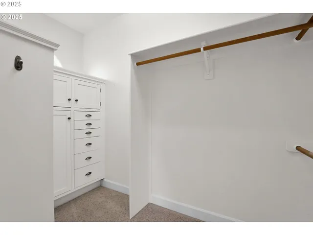 a view of walk in closet with clothes