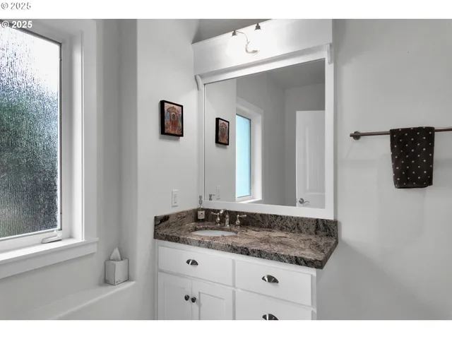 a bathroom with a granite countertop sink and a mirror