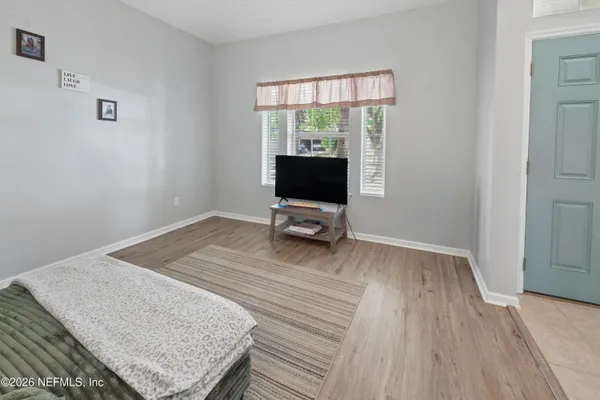 a bedroom with a bed and wooden floor