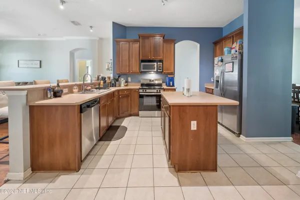 a kitchen with stainless steel appliances granite countertop a stove a sink dishwasher and a refrigerator