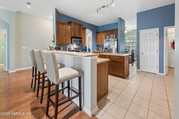 a dining room filled a chandelier and kitchen view