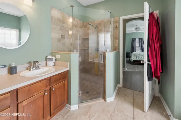 a en suite bathroom with a shower sink and mirror
