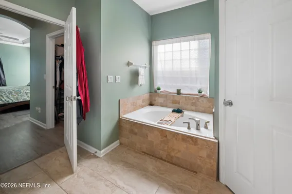 a bathroom with a tub a sink and a window