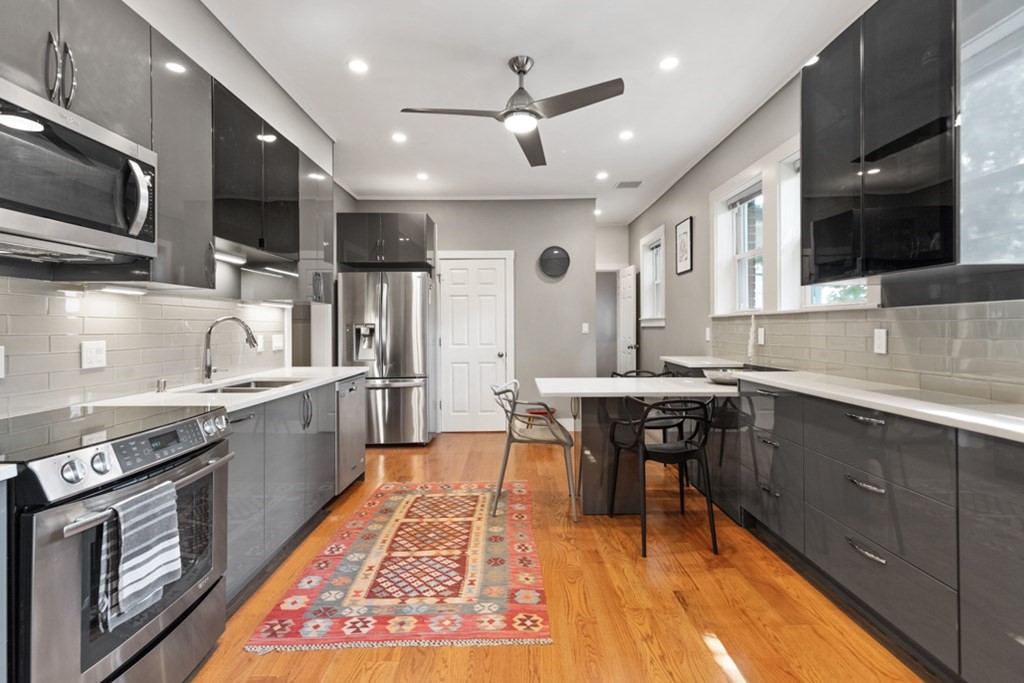 102 Addington Road, Unit 2 Brookline, MA 02445 - Photo 15 of 30 a large kitchen with stainless steel appliances granite countertop a sink dishwasher a stove and a microwave oven with cabinets