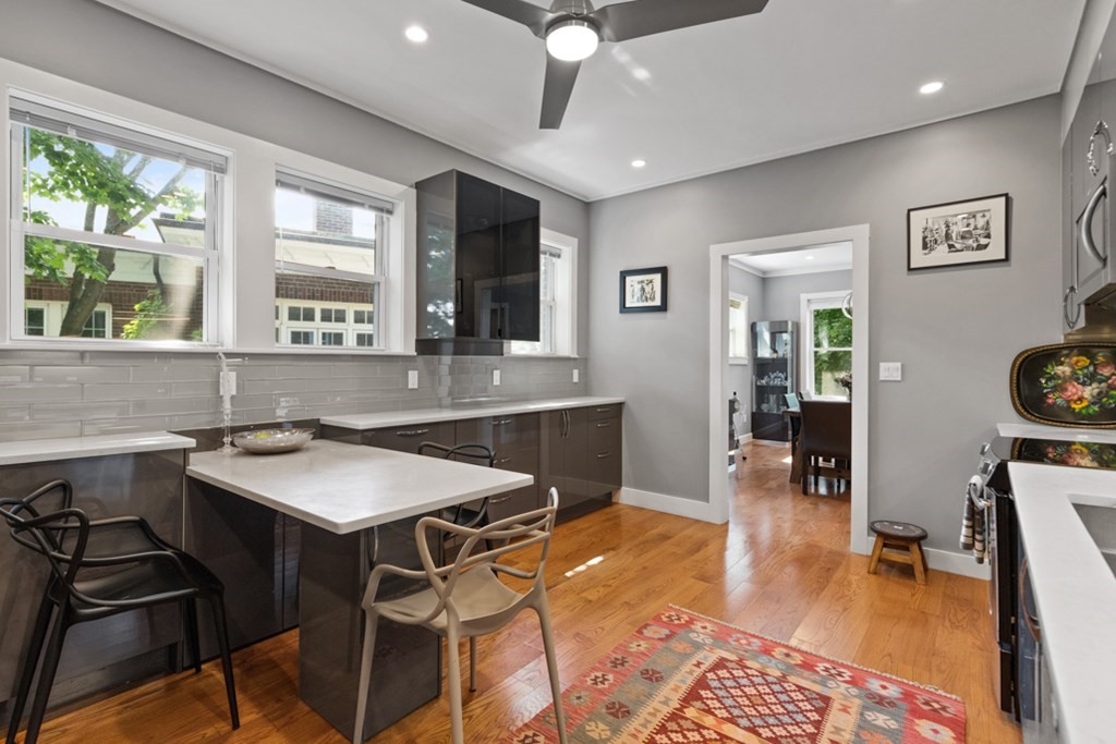 102 Addington Road, Unit 2 Brookline, MA 02445 - Photo 18 of 30 a kitchen with a sink a stove a dining table and chairs with wooden floor