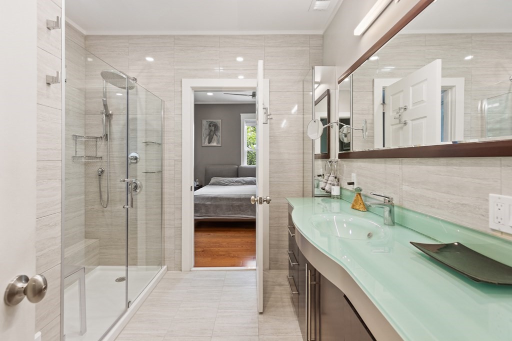 102 Addington Road, Unit 2 Brookline, MA 02445 - Photo 27 of 30 a spacious bathroom with a shower sink and mirror