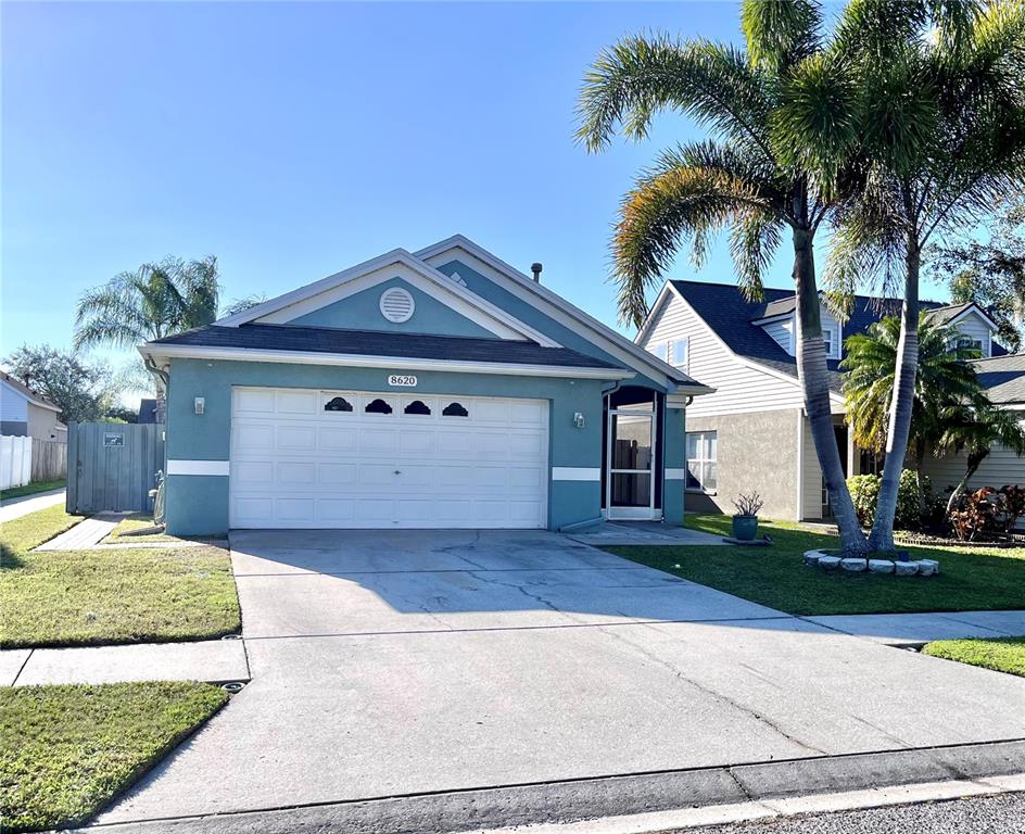 8620 Persea Court New Port Richey, FL 34655 - Photo 12 of 14 a front view of a house with a garden and trees