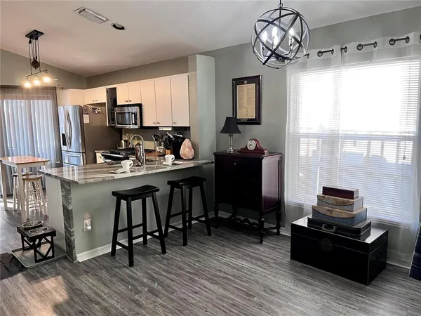 a view of a kitchen with dining room and wooden floor