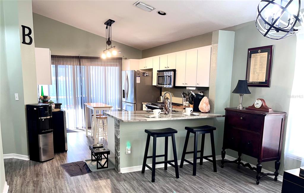 8620 Persea Court New Port Richey, FL 34655 - Photo 8 of 14 a view of a kitchen with dining room and wooden floor