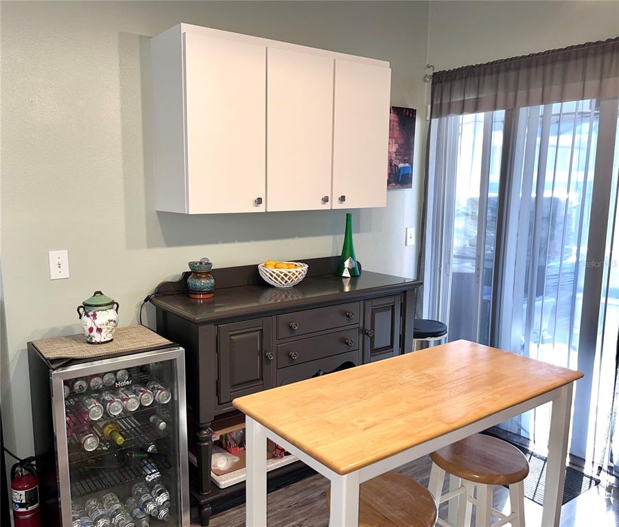 8620 Persea Court New Port Richey, FL 34655 - Photo 9 of 14 a room with a table chairs and a refrigerator