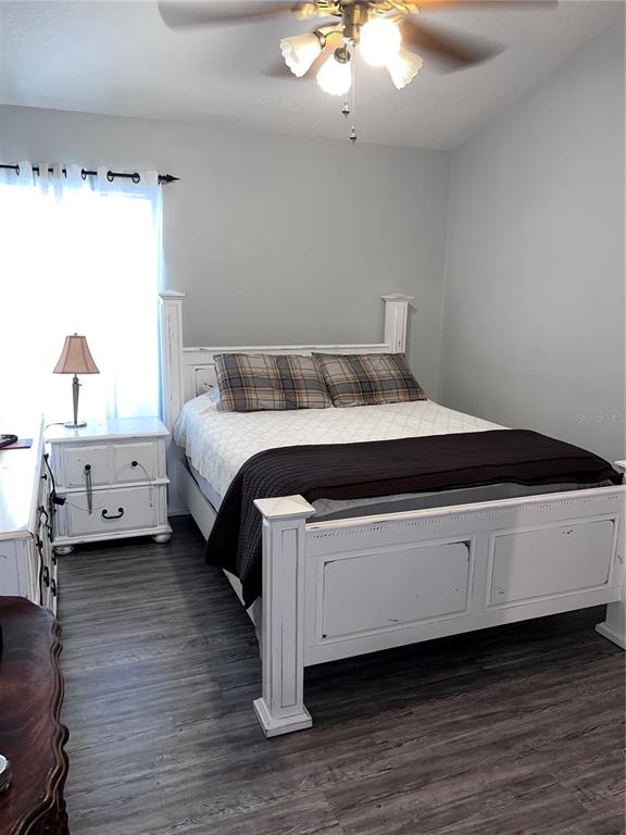 8620 Persea Court New Port Richey, FL 34655 - Photo 10 of 14 a spacious bedroom with a bed and a chandelier