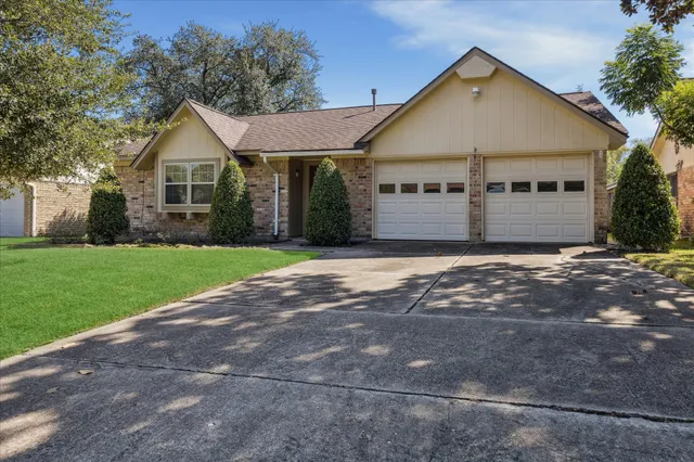 a view of a house with a yard and large tree