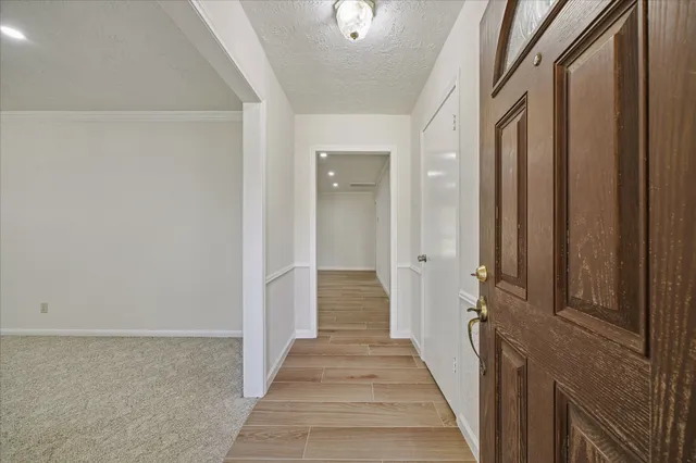 a view of a hallway with wooden floor and staircase
