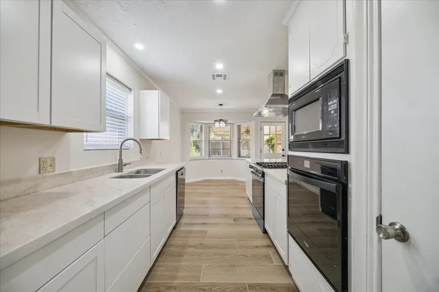 a large kitchen with stainless steel appliances granite countertop a sink stove and refrigerator