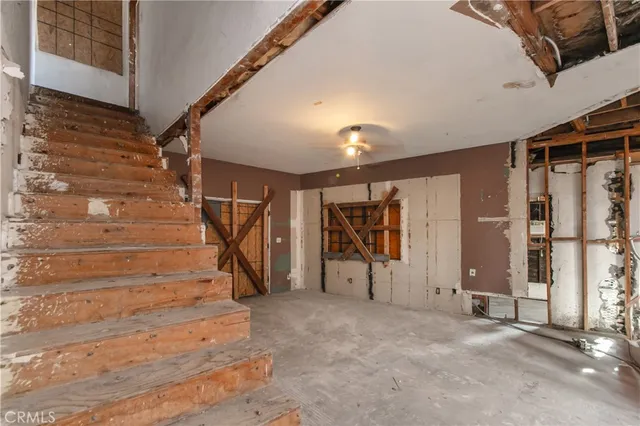 a view of empty room with stairs and mirrors