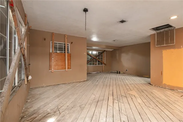 a view of a livingroom with wooden floor and staircase