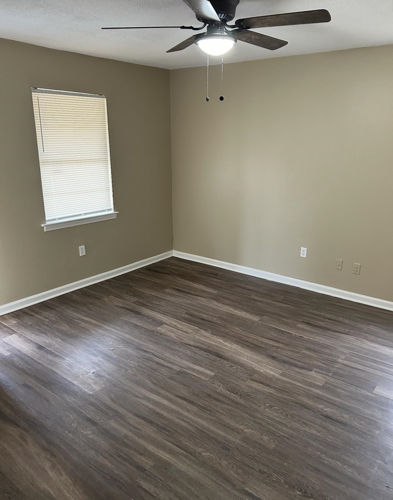 3396 Outlet Road Memphis, TN 38109 - Photo 4 of 6 an empty room with wooden floor and windows