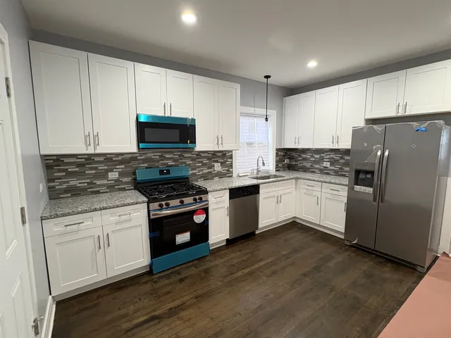 a kitchen with granite countertop white cabinets and white appliances