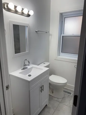 a bathroom with a toilet sink and mirror