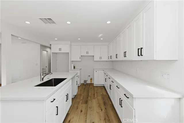 a kitchen with granite countertop a sink and cabinets