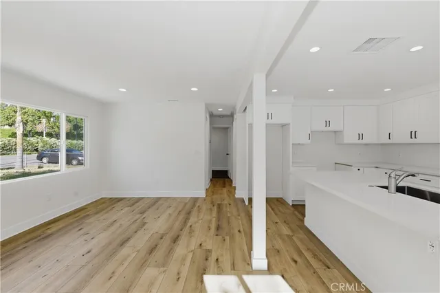 a view of a kitchen with wooden floor and a window