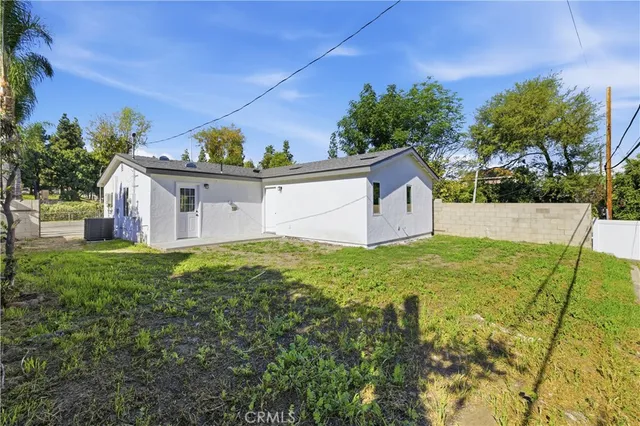 a backyard of a house with plants and large trees