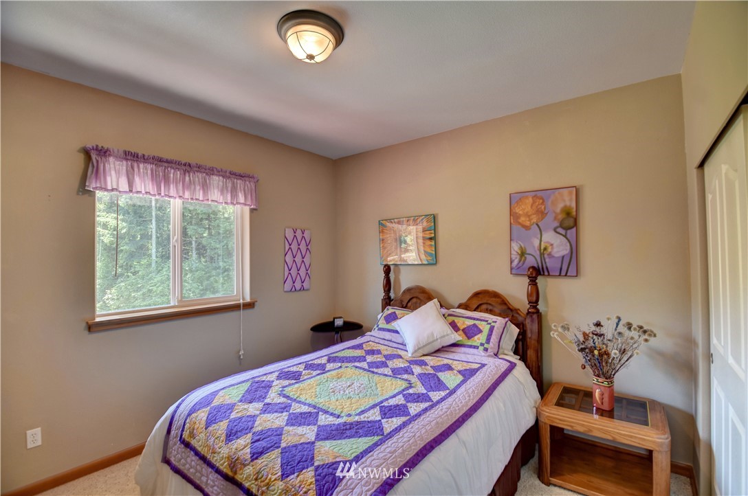 15837 Case Road Southwest Rochester, WA 98579 - Photo 17 of 40 a bedroom with a bed and a chandelier