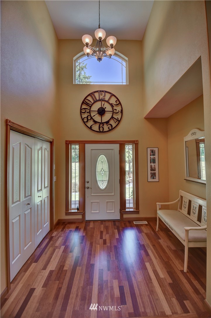 15837 Case Road Southwest Rochester, WA 98579 - Photo 3 of 40 a view of a hallway with wooden floor and a chandelier