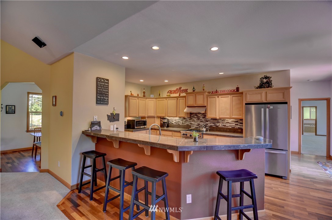 15837 Case Road Southwest Rochester, WA 98579 - Photo 6 of 40 a kitchen with stainless steel appliances a dining table chairs and wooden floor