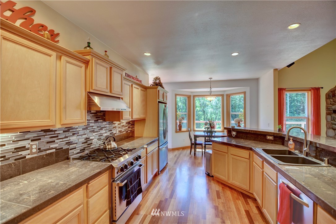 15837 Case Road Southwest Rochester, WA 98579 - Photo 9 of 40 a kitchen with lots of counter top space a stove a sink and a window